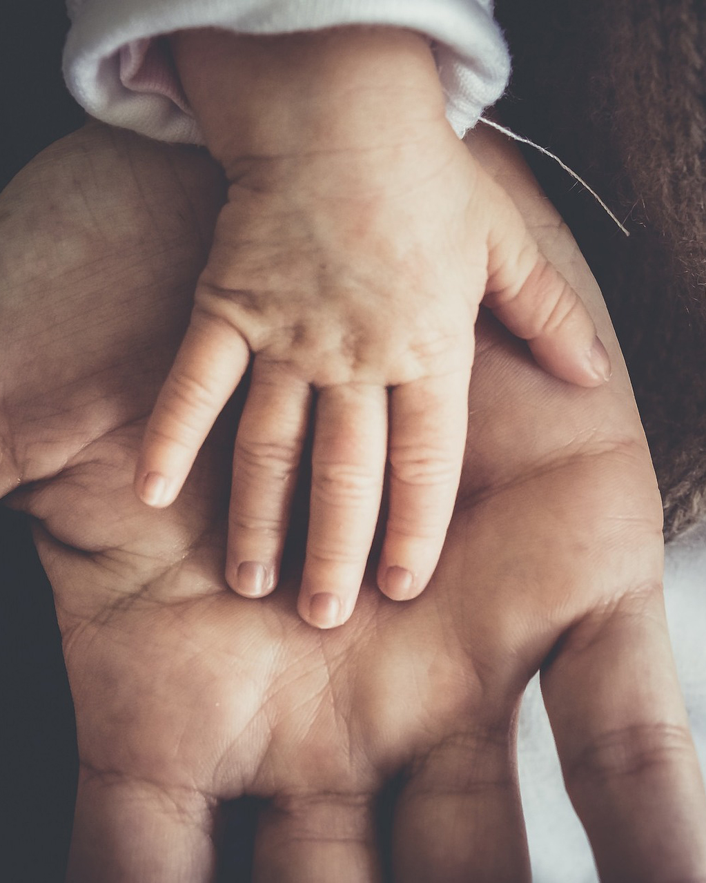 voksenhand og barnehand holder hverandre med kjaerlighet etter akutthjelp fra alle barna sover